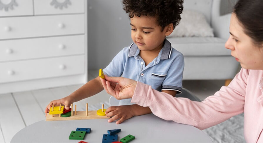 A teacher guiding a young child through a shape-sorting activity